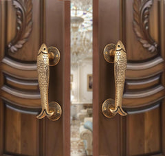 Brass fish design door handle pair with round backplates, shown on a door.