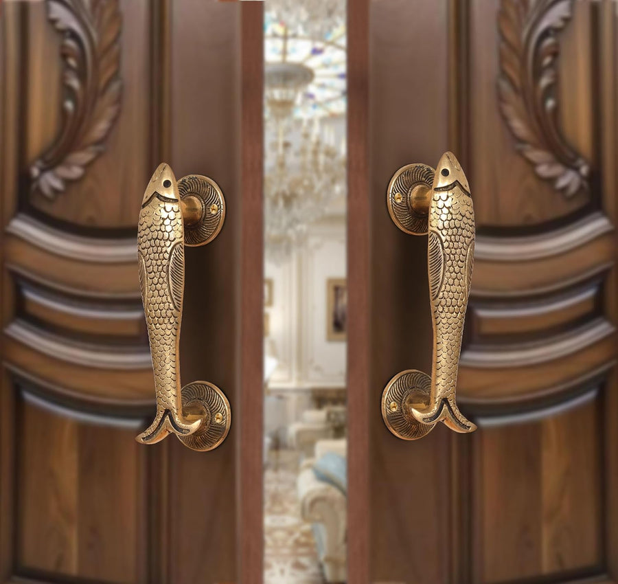 Brass fish design door handle pair with round backplates, shown on a door.