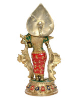 Radha brass idol back view, large gold droplet aura, green blouse, red patterned skirt