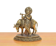 Brass Lord Krishna statue playing flute on cow idol with ornate round base
