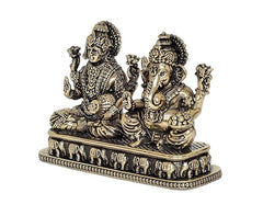 Brass Lakshmi and Ganesha idol, angled view showing carved figures and base