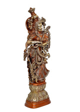 Radha Rani brass idol statue angled view with large headdress and decorative garlands