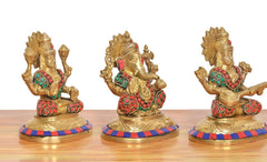 Brass Lakshmi, Ganesh and Saraswati idols, angled view; colorful jewelry and patterned base