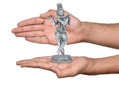 Brass Lord Krishna flute idol held in hands, detailed circular base