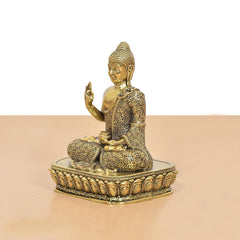 Bronze Buddha idol side profile with raised right hand in Abhaya mudra, ornate base