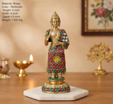 Brass standing Buddha idol on white base, Abhaya mudra, multicolor jeweled red robe