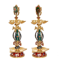 Pack of 2 brass shankh chakra oil lamps, side view of green and red enamel idols