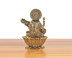 Brass Maa Saraswati idol on lotus, back view with halo ornamentation.