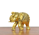 Golden brass elephant figurine, front side view showing legs and decorative embossing.