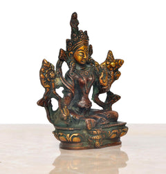 Four-armed Tara Devi figurine, greenish patina and gold accents, seated on lotus throne.
