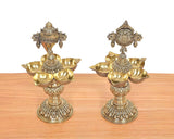 Close view of brass shankh diya stand with five bowls and Vishnu emblem at top