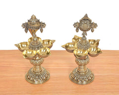 Close view of brass shankh diya stand with five bowls and Vishnu emblem at top