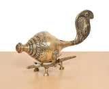 Brass shankh conch ornament with carved bands and decorative tail on a small stand
