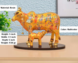 Multicolor resin Kamdhenu cow with calf figure, height 8 inch, on round base.