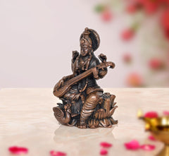 Back view of Saraswati Maa statue, copper-toned bronze, seated with veena