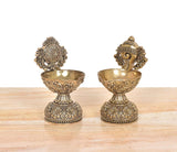 Pair of brass diya shankh oil lamp stands with ornate bowls and carved bases