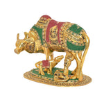 Side view gold cow statue with calf, Bal Krishna figure and red-green jeweled cloth