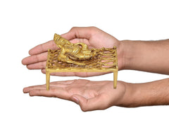 Brass Ganesha on charpai cot held in hands, compact temple pooja decor