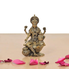 Lakshmi brass idol with symbolic objects in both hands, seated on lotus base