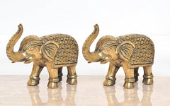 Brass elephant figurines, angled view of 2 elephants with patterned backs and raised trunks