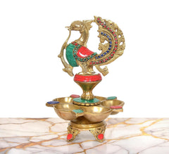 Ornate brass five-diya oil lamp stand with peacock figure and jeweled ring