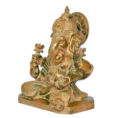 Close view of brass Ganesha idol head with crown details and halo backplate