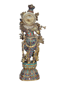 Back view of brass Krishna murti with flute, ornate halo and colorful dress