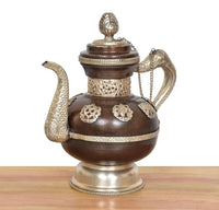 Ornate brass teapot showpiece with decorative side handles, chain, and domed lid finial