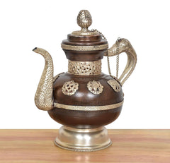 Ornate brass teapot showpiece with decorative side handles, chain, and domed lid finial