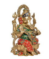 Brass Ganesha statue, angled slightly right, jeweled green blouse and red skirt
