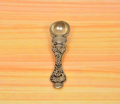 Bronze pooja spoon end view with fluted foot, ornate scrollwork, and round bowl