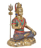 Brass Shiva murti with trident, seated legs, detailed colorful stone inlay