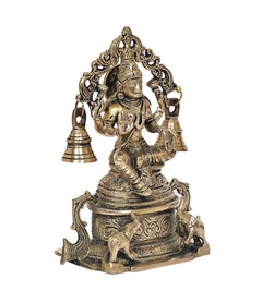 Brass Lakshmi idol side view with detailed drapery and four bells on arch