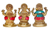 Back view of three brass deity idols with detailed halos and teal-red garments