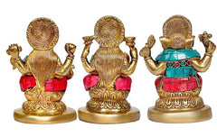 Back view of three brass deity idols with detailed halos and teal-red garments