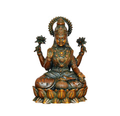 Lakshmi brass idol facing forward, ornate crown, four arms, seated on a lotus base