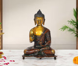 Brass Buddha statue seated in Abhaya mudra, gold face and dark robe, 9-inch