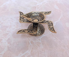 Brass diya oil lamp top view with decorative leaf-like arms and sunburst bowl