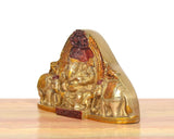 Brass Ganesha idol side view with elephants, red and gold painted accents