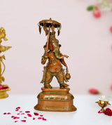 Brass Ganesha idol statue holding parasol, ornate green accents, pedestal base