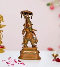 Brass Ganesha idol statue holding parasol, ornate green accents, pedestal base