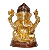 Brass Ganesha statue, gold finish with dark crown accents, seated with hands raised