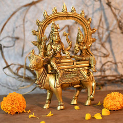 Brass Shiva Parvati idol on Nandi, side view with raised trident and jewelry