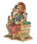 Side view of sitting Ganesha statue in gold tones with jeweled teal-green trim and red accents