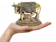 Brass cow with calf figurine held in hand for size, ornate etched saddle panel