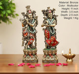 Bronze Radha-Krishna idol pair, front view with jeweled red-green dresses and crowns