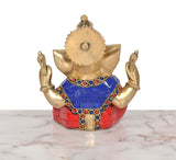 Back view of 6-inch brass Ganpati idol, blue-red outfit with gold back medallion