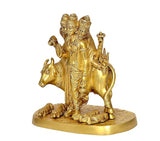Side view of brass Trimurti idol on cow, tall headdress, raised hand and trident