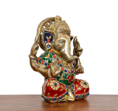 Ganesha idol side view, gold trunk and crown with green-red decorative clothing