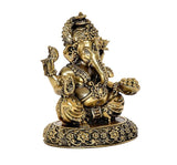 Brass Ganesha statue angled view, one hand raised, ornate jewelry on pedestal base